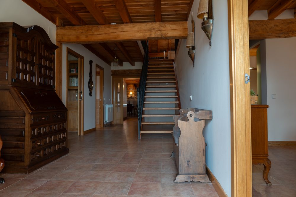 Pasillo con escalera y muebles antiguos